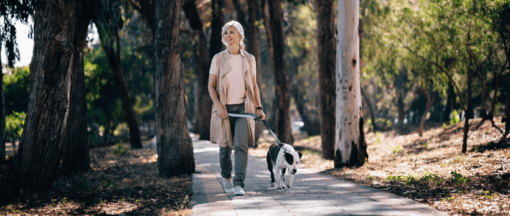 nő sétáltatja foltos kutyáját a parkban