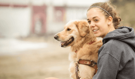 golden retriever gazdájával ül boldogan