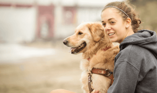 golden retriever gazdájával ül boldogan